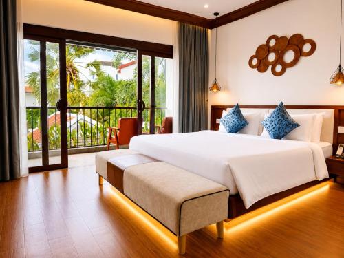 a bedroom with a large bed and a balcony at Happy Resort Siem Reap in Phumi Ta Phul