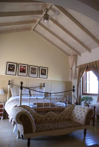 a bedroom with a bed with a couch in it at Olive Tree House in Anoyira