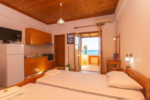 a room with two beds and a kitchen with the ocean at Aeolos seaside studios in Frangokastello