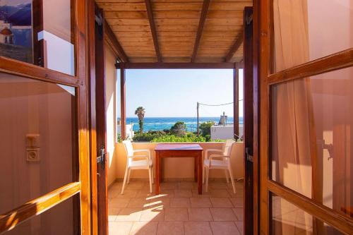 a dining room with a table and a view of the ocean at Aeolos seaside studios in Frangokastello