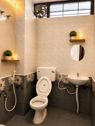 a bathroom with a toilet and a sink at La Muthu Beach Stay in Pondicherry