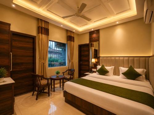 a bedroom with a large bed and a table at Hotel Geet Deluxe Near Connaught Place and New Delhi Railway Station in New Delhi