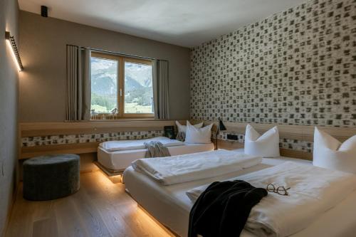 a hotel room with two beds and a window at Arabella Retreat & Spa in Nauders