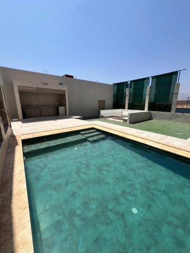 a swimming pool in front of a building at Villa privée avec piscine chauffée in Oulad Teïma