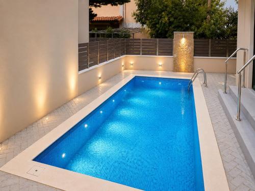 a swimming pool with lights on the side of a house at Agora Luxury Villa I in Loutraki