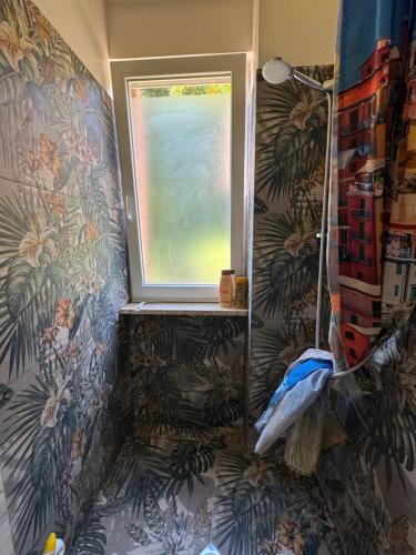 a bathroom with a window and a wall with plants at Rome - Green Hills condominio in Colleverde