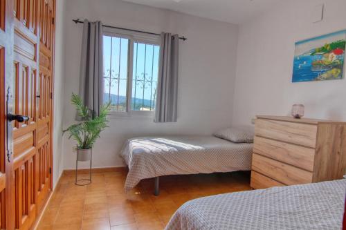 a bedroom with two twin beds and a window at Casa Morendo in Teulada