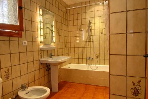 a bathroom with a toilet and a sink and a tub at Casa Morendo in Teulada