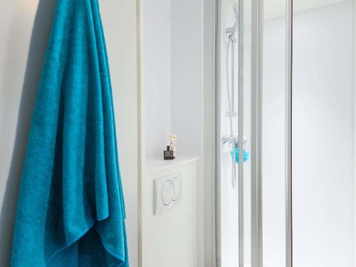 a bathroom with a blue towel next to a shower at hotelF1 Igny Massy TGV in Igny