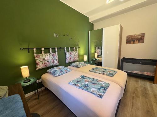 a bedroom with a large bed and a green wall at Rome - Green Hills condominio in Colleverde