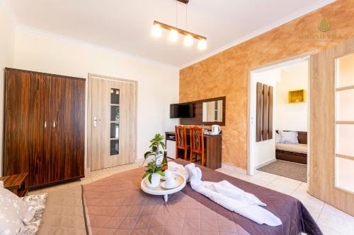 a room with a bed and a living room at GRAND VILLA USTKA- POKOJE z BALKONAMI I TARASAMI, PARKING W CENIE ! in Ustka