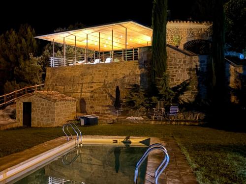 a swimming pool in front of a building at night at Villa Natalia in Monroyo