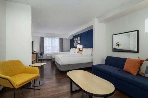 a hotel room with a bed and a couch at City Express By Marriott Findlay in Findlay