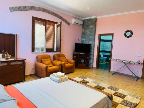 a living room with a bed and a tv at Busulla Guest House in Shijak