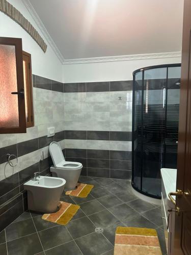 a bathroom with a toilet and a sink at Busulla Guest House in Shijak