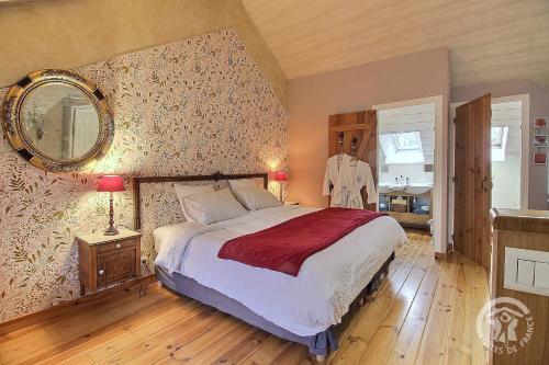 a bedroom with a bed and a mirror on the wall at La Guyonnais Chambre d'hôtes in Quévert