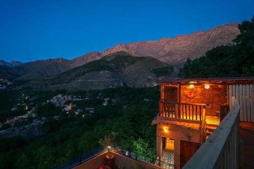 a building with a balcony with a view of mountains at Atlas Prestige in Imlil