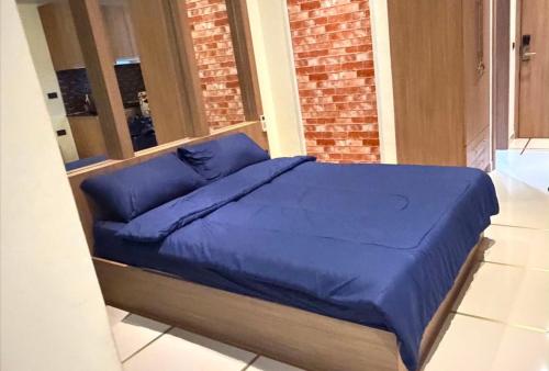 a bed with a blue blanket on top of it at Nam Talay Condo Monthly only in Na Jomtien