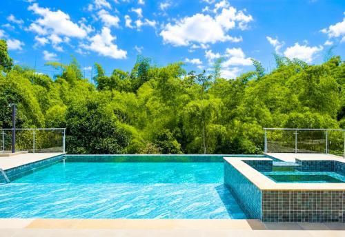a swimming pool with trees in the background at Balcón de Antioquia Exclusiva Villa Campestre con Piscina Privada, Jacuzzi y BBQ en el Eje Cafetero, cerca del Parque del Café in Montenegro