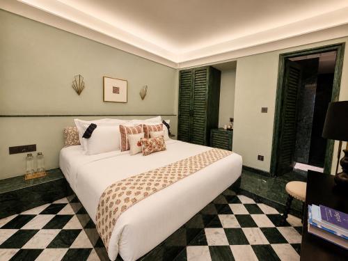 a large white bed in a room with a checkered floor at Abode Jaipur in Jaipur