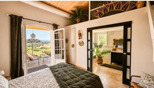 a bedroom with a bed and a door to a balcony at La Bastide de Grosille in Savasse