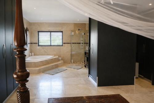 a large bathroom with a tub and a shower at Salt and stone in Cape Town