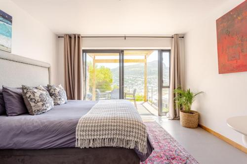 a bedroom with a bed and a large window at Beachfront Bliss in Cape Town