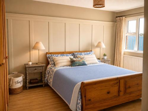 a bedroom with a bed and two lamps and a window at Grovehouse in Portstewart