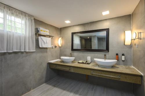 a bathroom with two sinks and a mirror at Canary Kendwa Beach Resort in Kendwa