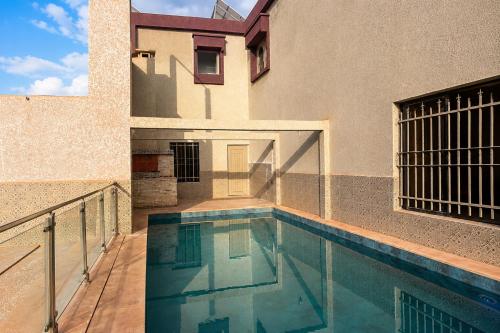a house with a swimming pool next to a building at Villa privée avec piscine chauffée in Oulad Teïma
