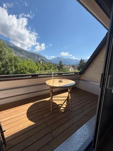 a table on a balcony with a view of the mountains at Dove house in Barcelonnette