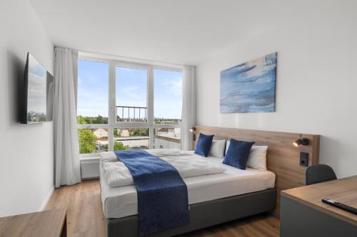 a bedroom with a bed and a large window at Tower Hotel Frankfurt in Frankfurt