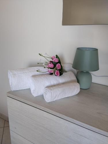 a table with towels and a lamp and a bouquet of flowers at Casa Vacanze Daniele in Pontecagnano