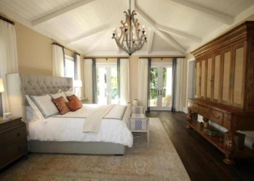 a bedroom with a large white bed and a chandelier at Skyline Grand Hotel - Near IGI New Delhi Airport in New Delhi