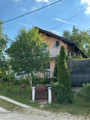 a house with a red fence in front of it at Vikendica Cokori - private pool and jacuzzi in Banja Luka