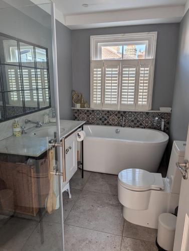 a bathroom with a tub and a toilet and a sink at Rusthall Prospect House in Speldhurst