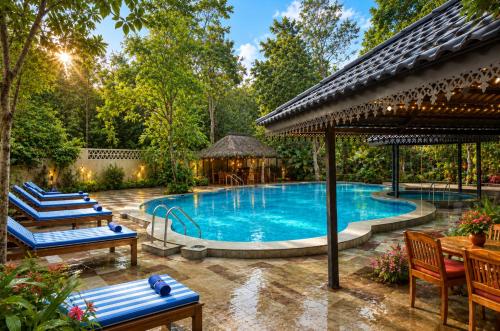 an outdoor pool with chairs and a gazebo at Sterling Padam Pench in Khawāsa