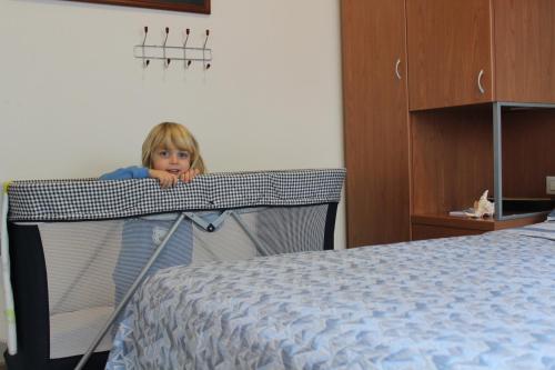 a little girl is hiding behind a bed at Residence Veliero in San Mauro a Mare