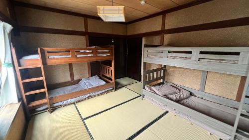 a small room with two bunk beds in it at ゲストハウス のまー in Komagane