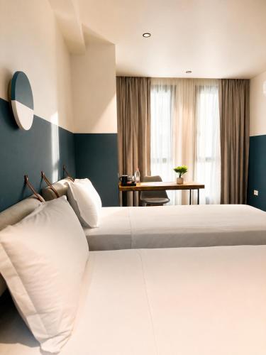 a hotel room with two beds and a desk at Rich Hotel Vlore in Vlorë