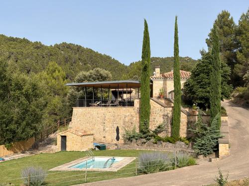 a stone house with a swimming pool in a yard at Villa Natalia in Monroyo