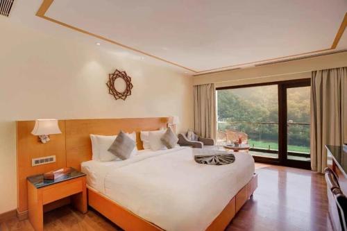 a bedroom with a large bed and a large window at Apni Haveli Hotel and Restuarant in Bhojpur