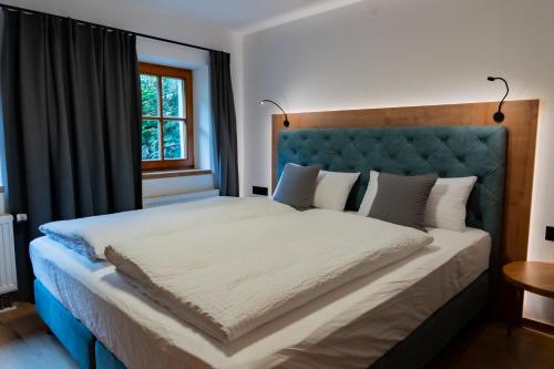 a bedroom with a large bed with a blue headboard at N47 Apartments Berchtesgaden in Berchtesgaden