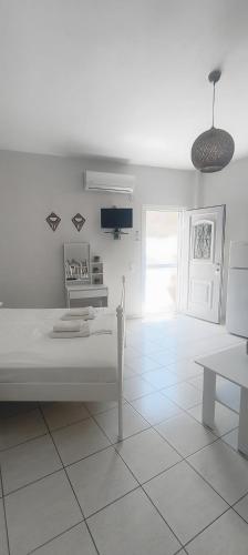 a white room with a bed and a table at Merichas 7 Irida in Mérikhas