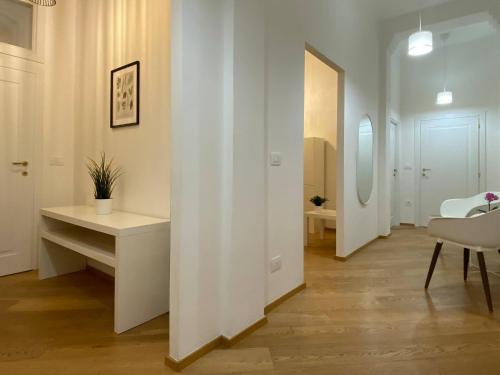 a hallway with white walls and a table and a chair at Porta Nova, Bologna by Short Holidays in Bologna