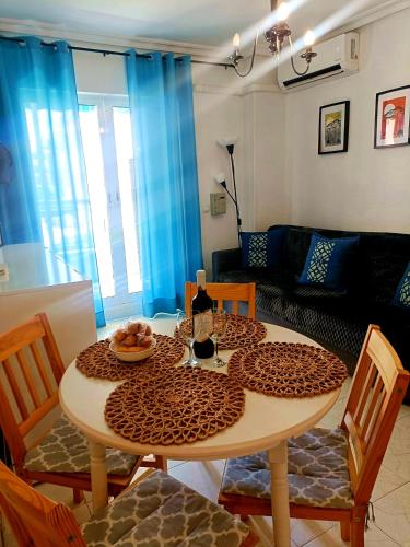 a table and chairs in a living room with a table and a couch at Apartament La Mata "FELIZ" in La Mata