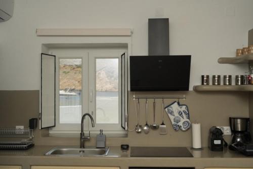 a kitchen counter with a sink and a window at Onar Sifnos by the sea in Cherronisos