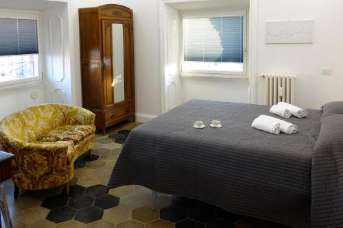 a bedroom with a bed with a chair and towels at La Rosa del Vaticano Luxury Apartment in Rome