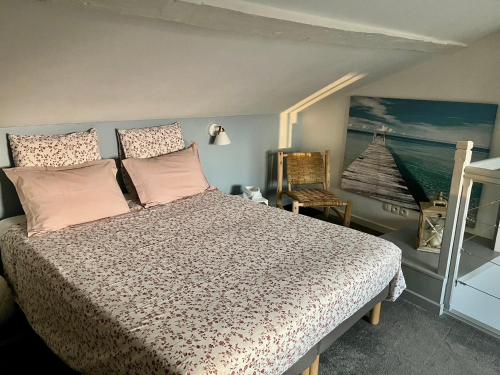 a bedroom with a bed with pink pillows and a painting at La loge des Salinières in Bordeaux