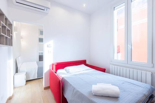 a red bed in a white room with a window at Garisenda, Bologna by Short Holidays in Bologna